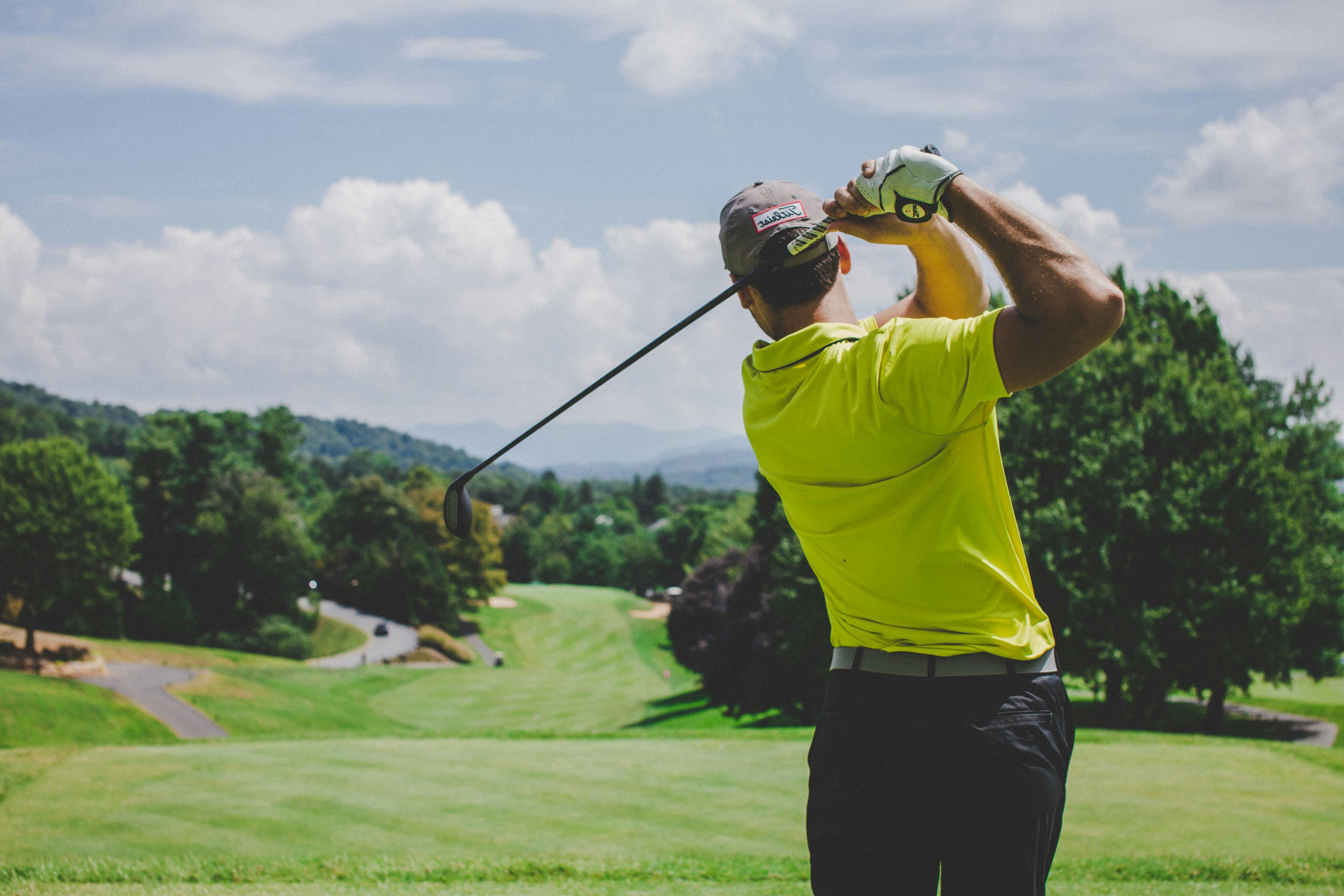 Golfer mid-swing on a scenic course